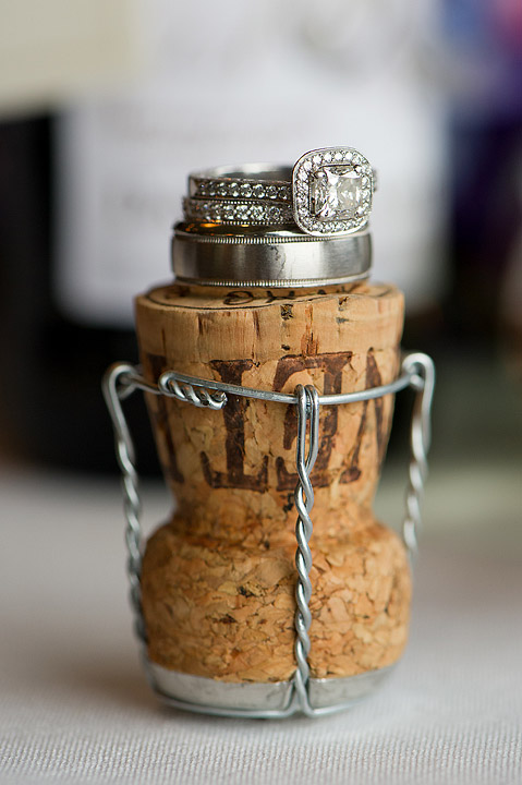 Stacked wedding rings displayed on a champagne cork