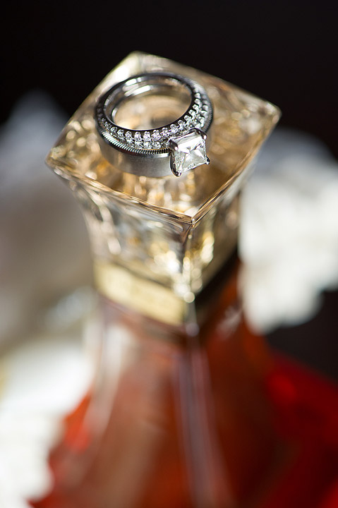 Wedding ring displayed on a square perfume bottle