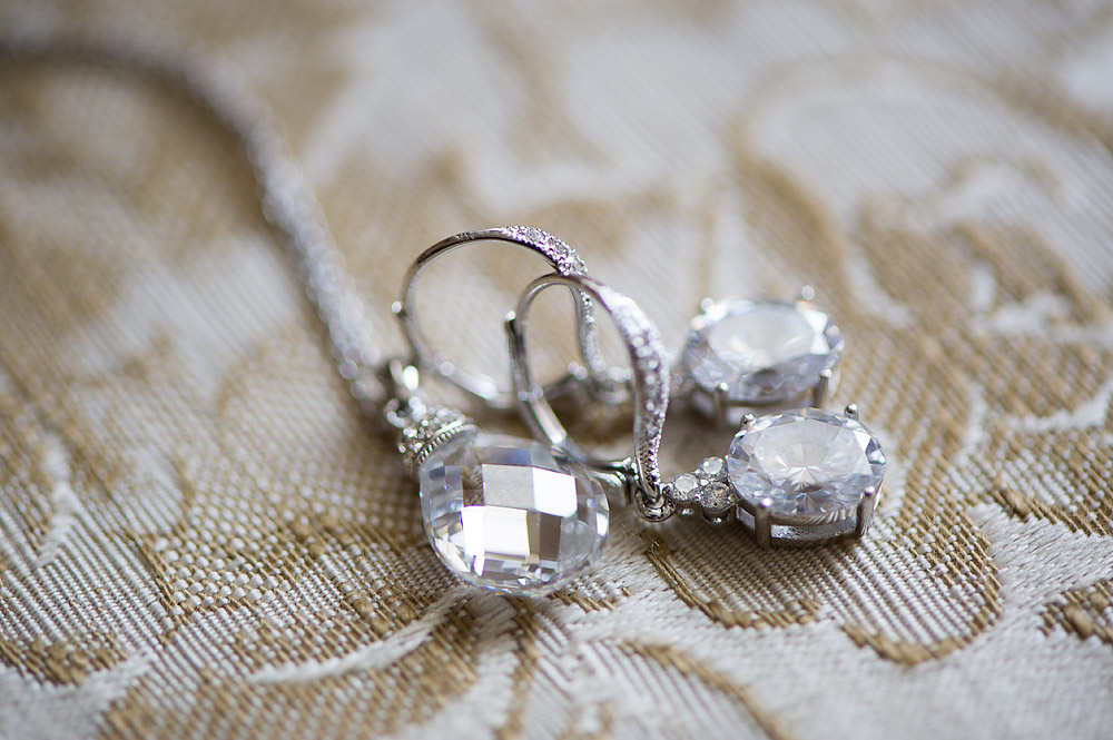 Crystal earrings arranged on patterned fabric