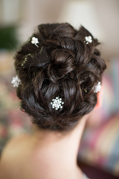 Braided bridal updo with small white floral pins