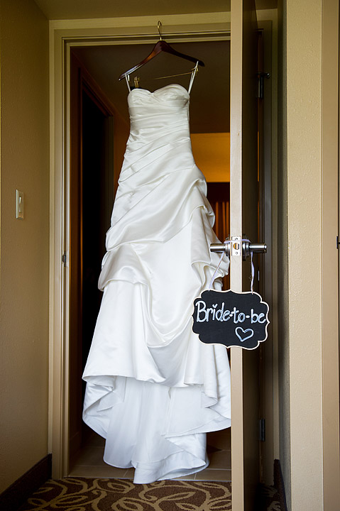 White wedding dress hanging in a doorway with a bride-to-be sign
