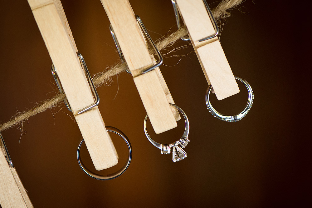 Wedding rings hanging from wooden clothespins