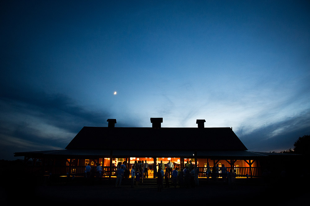 Rustic barn reception venue beneath a twilight sky and moon