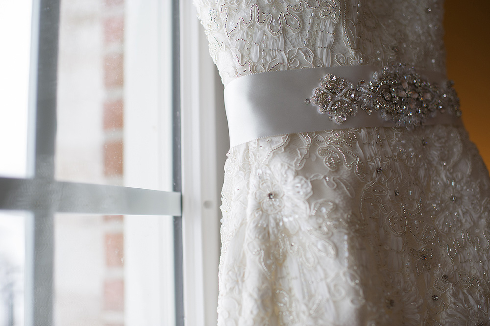Close-up of a beaded belt on a lace wedding dress