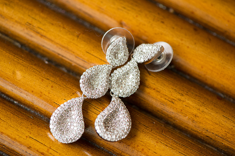 Sparkling drop earrings arranged on wood