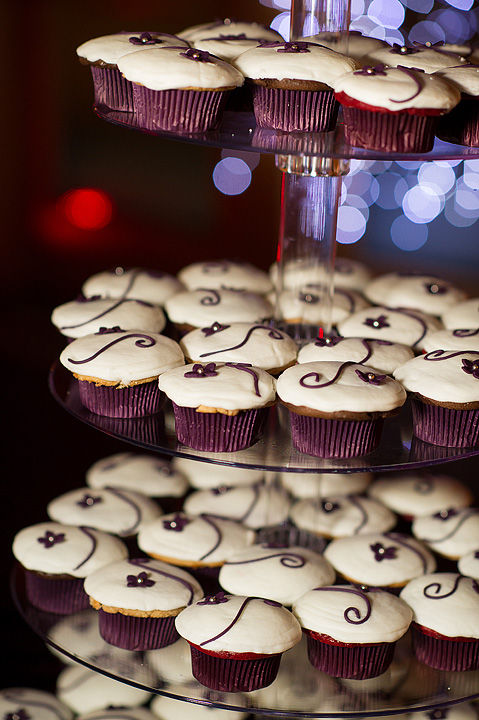 Purple-accented cupcakes displayed on a tiered stand