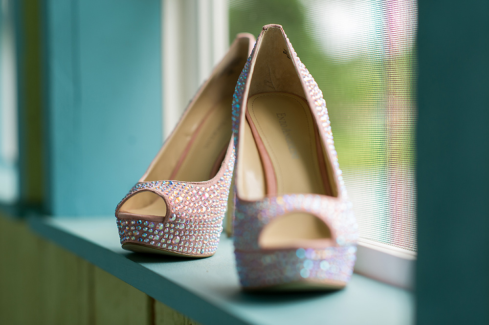 Glittery blush peep-toe bridal shoes on a window ledge