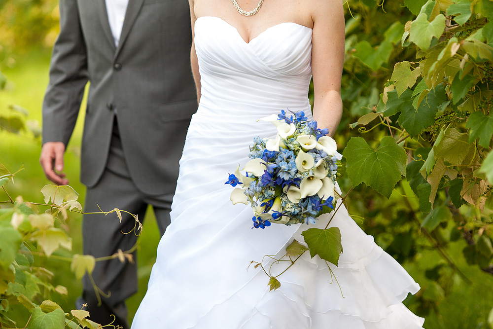 Bride holding a blue-and-white bouquet beside the groom