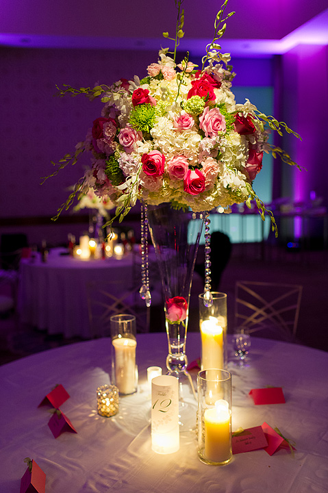 Tall pink-and-white floral reception centerpiece with candles