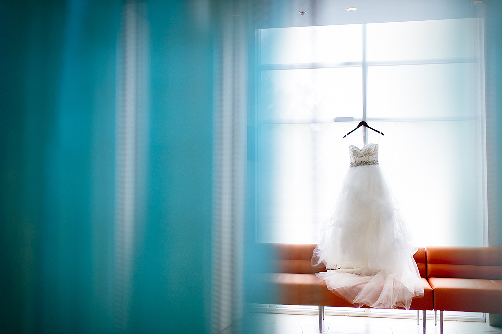 White wedding dress framed by teal curtains