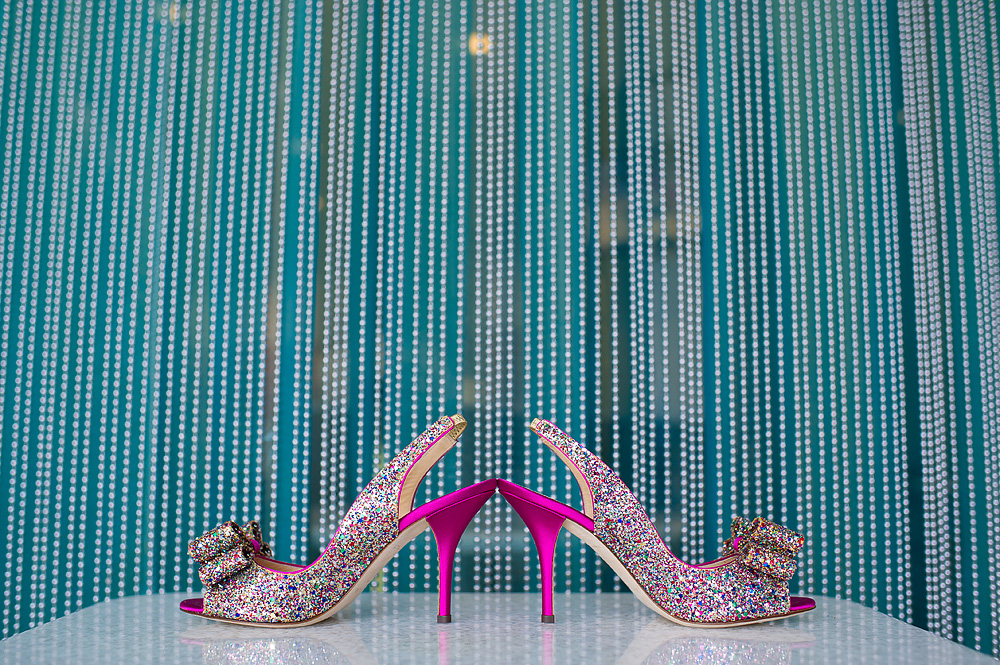 Colorful rhinestone bridal heels against a blue beaded backdrop