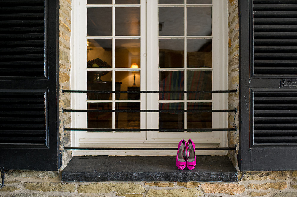 Bright pink bridal shoes outside French doors
