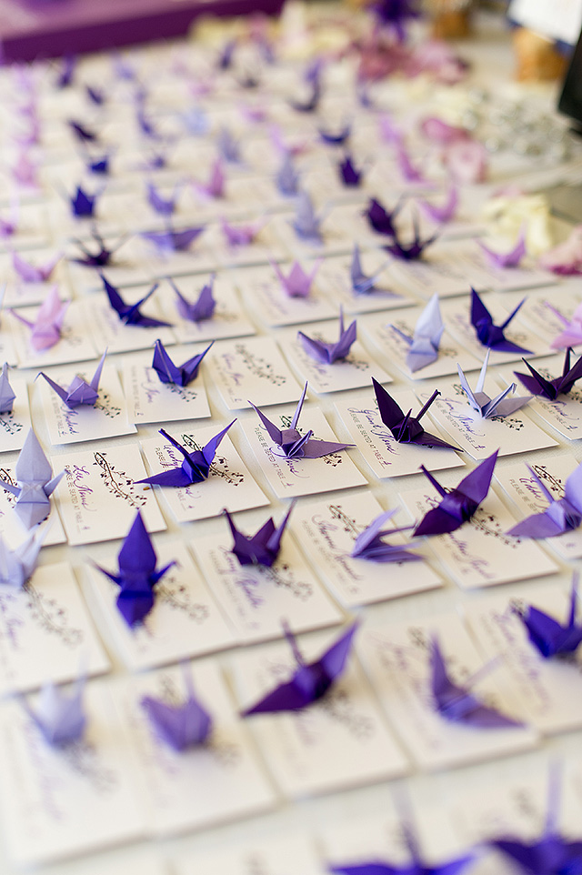 Purple origami cranes arranged across a wedding table