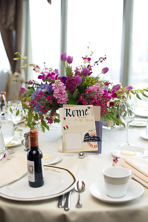 Purple floral centerpiece and table number on a reception table