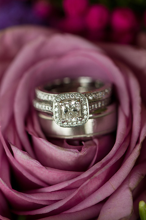 Stacked wedding rings nestled inside a purple rose
