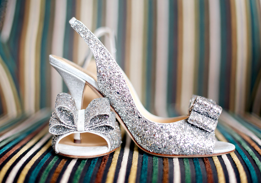 Glittering silver bow bridal shoes on a striped chair