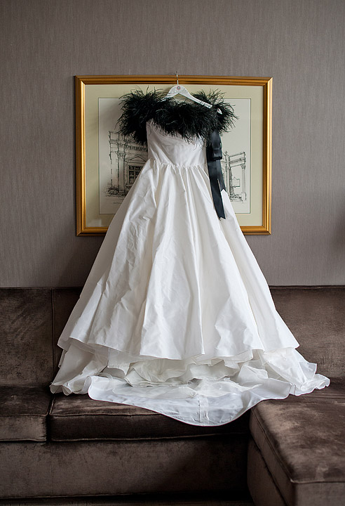 Strapless wedding dress displayed over a dark sofa