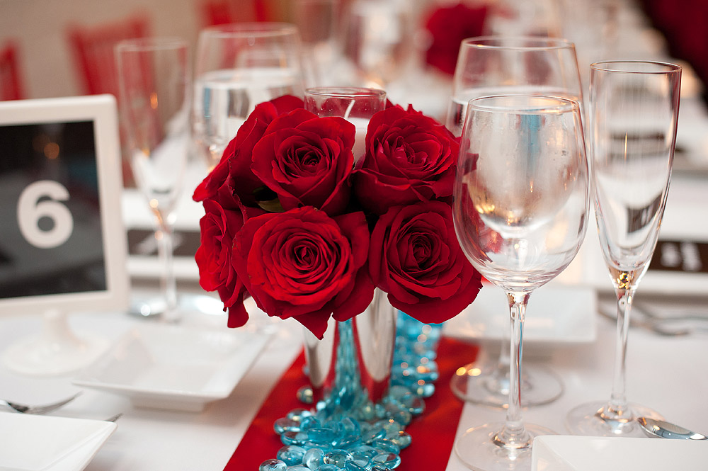 Red rose centerpiece with glassware on a reception table