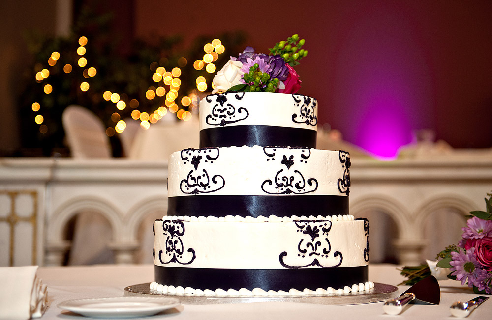 Black-and-white damask wedding cake at a purple-lit reception