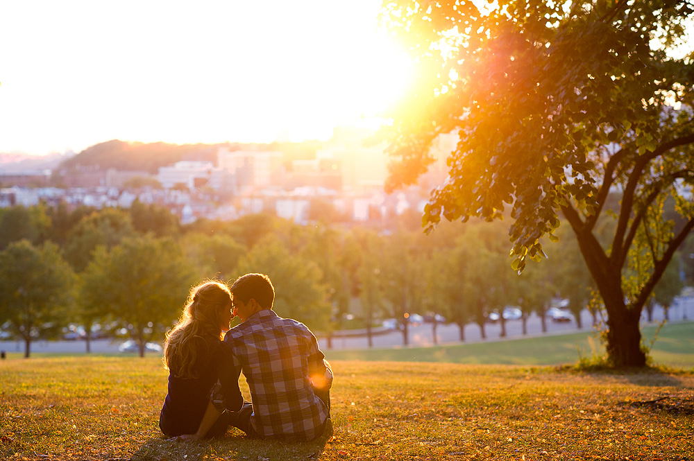 Couple seated beneath a tree overlooking Pittsburgh at sunset