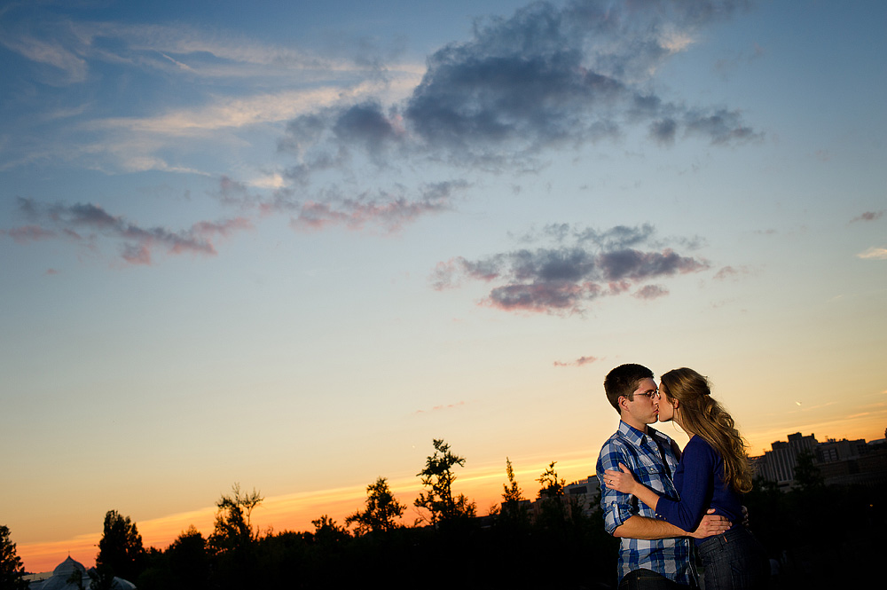 Couple kissing beneath a colorful sunset sky