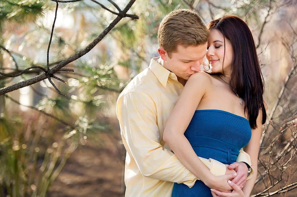 Couple embracing beneath the branches of a budding tree