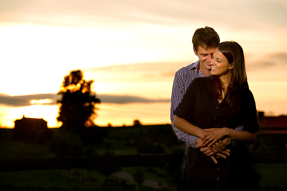 Couple embracing at sunset in an open field