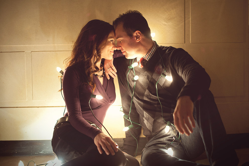 Couple wrapped together in glowing string lights