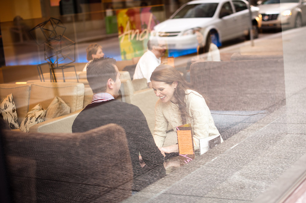 Couple seen through a restaurant window at a sidewalk table