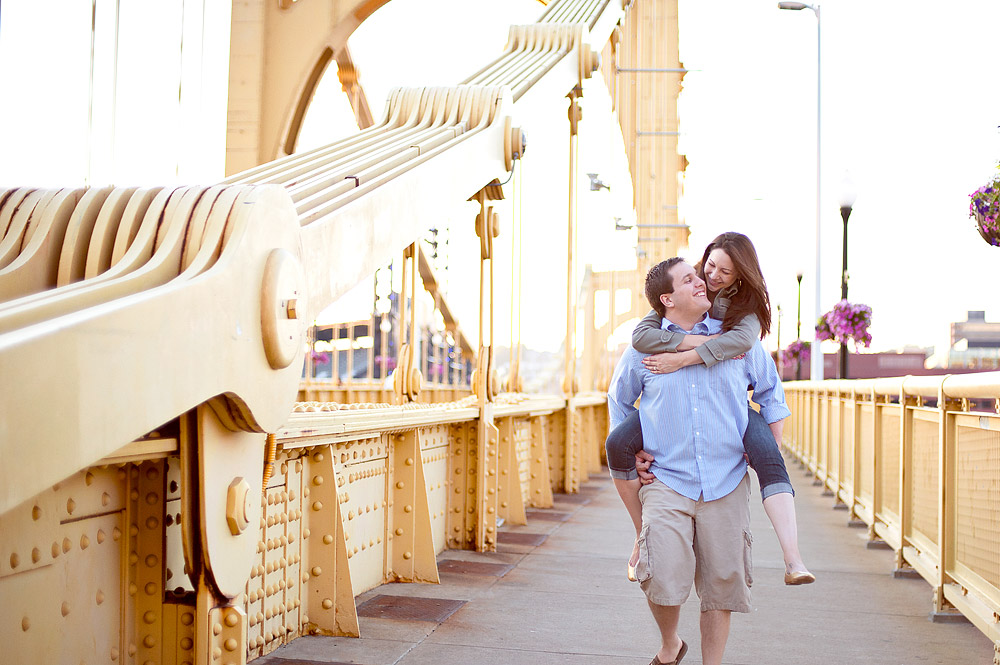 Playful piggyback pose on a yellow Pittsburgh bridge