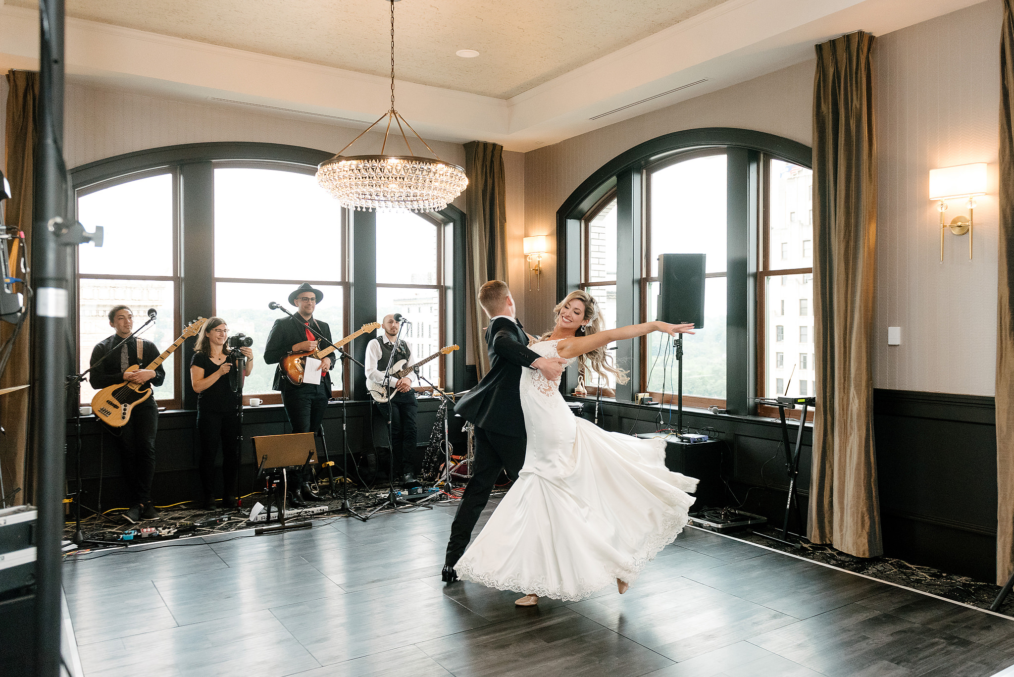 Newlyweds dancing in a ballroom while a band performs