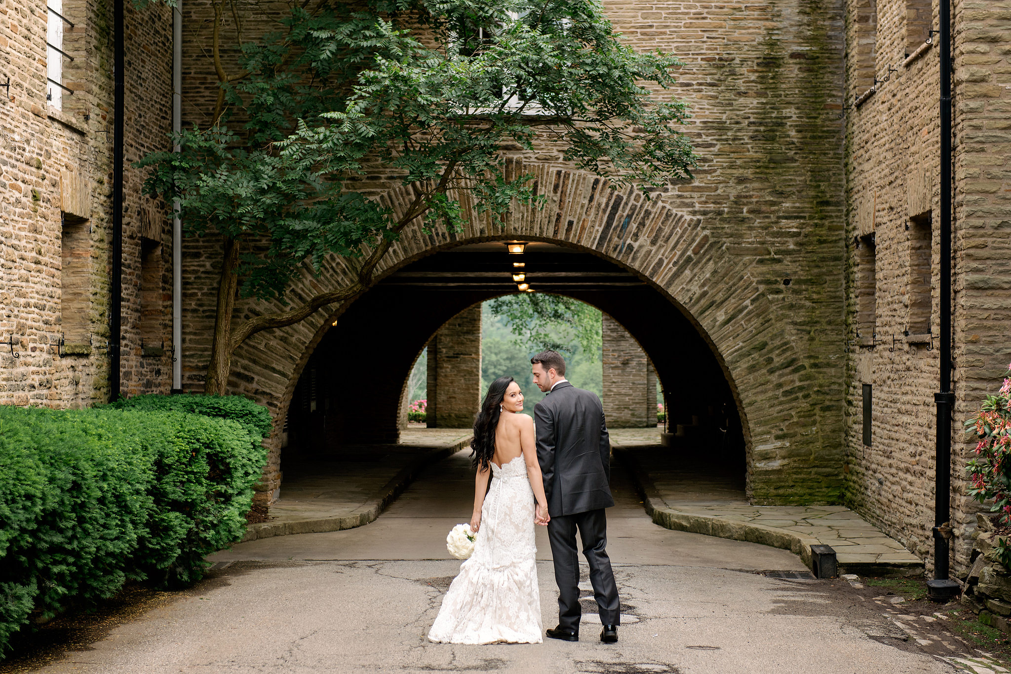 Wedding couple framed by a brick arch at a golf club