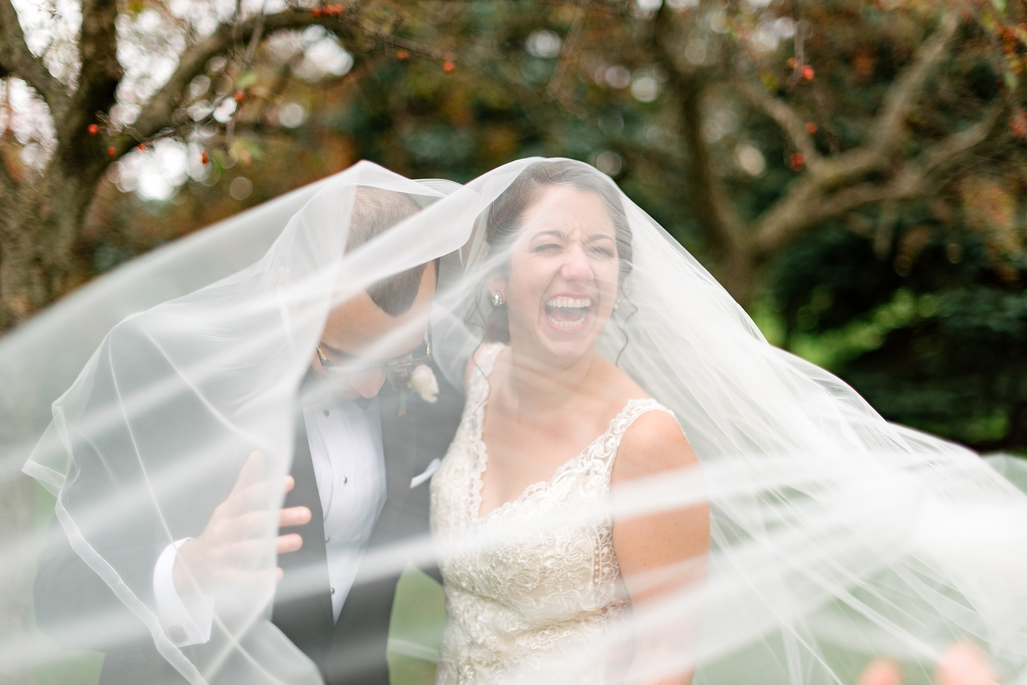 Smiling bride beneath her flowing wedding veil
