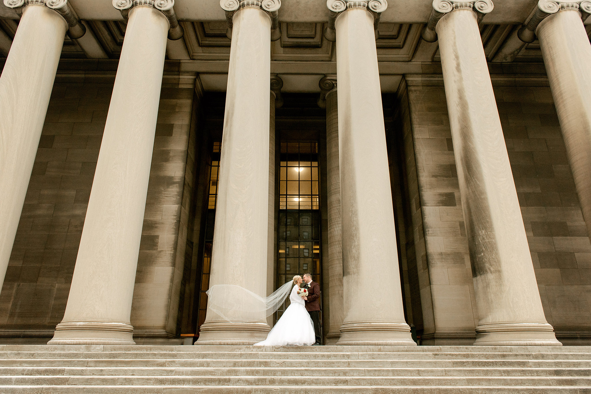 Bride and groom beneath the columns of Pittsburgh's Mellon Institute