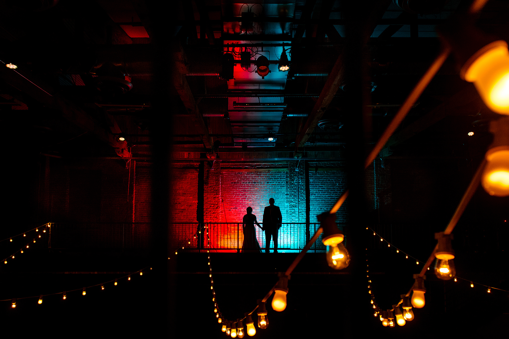 Wedding couple silhouetted in red-and-blue light at Pittsburgh Opera