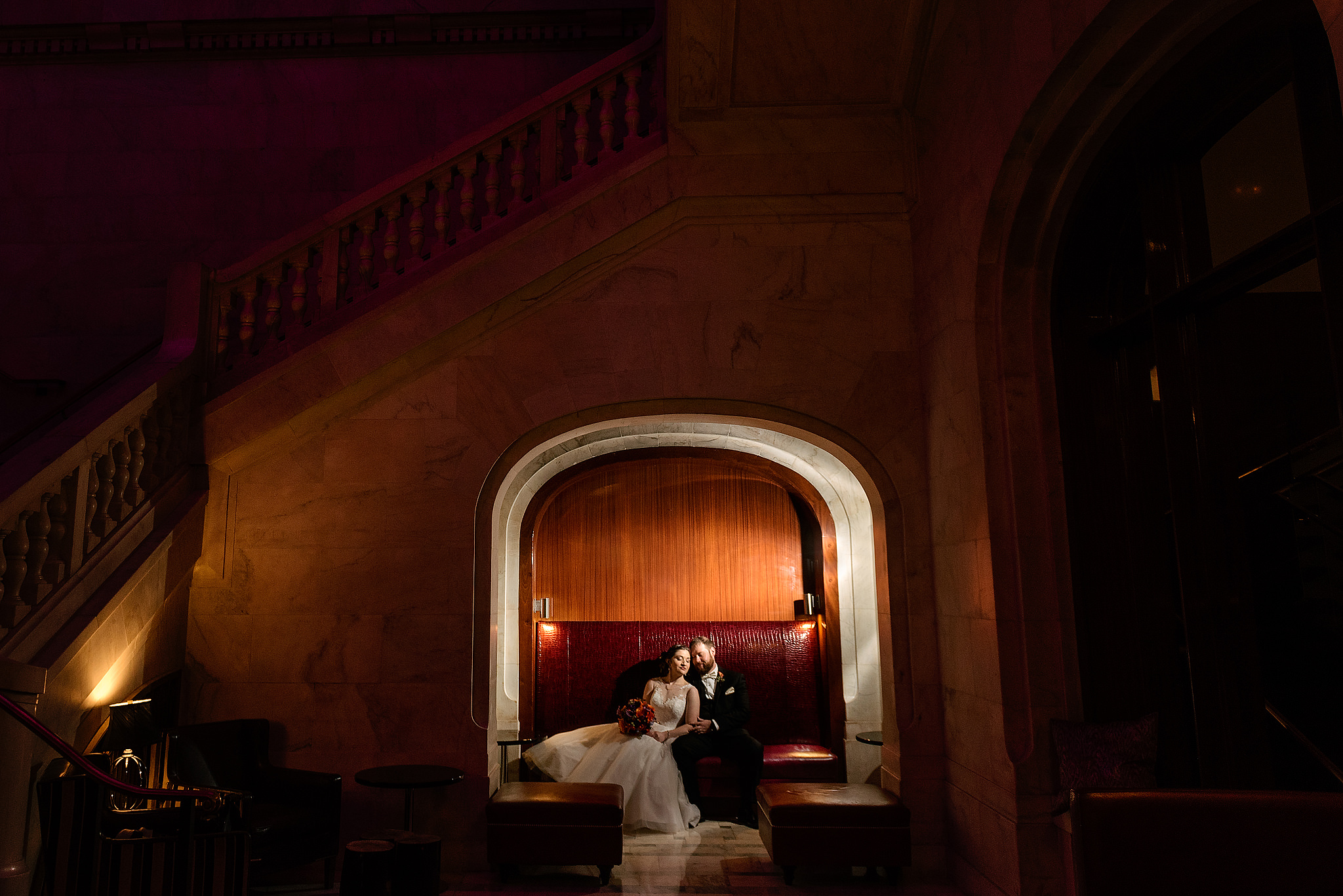 Newlyweds seated before a large fireplace at the Renaissance Pittsburgh Hotel