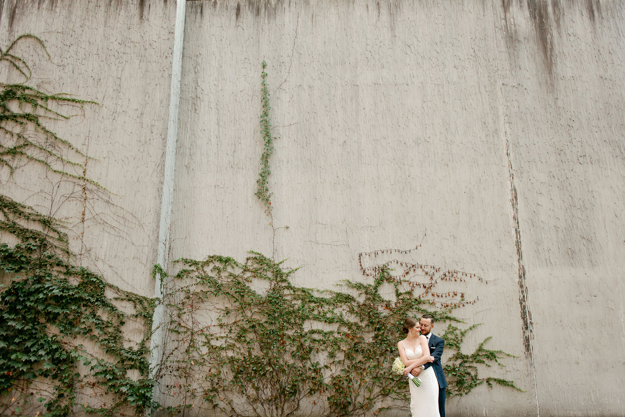 Wedding couple beside an ivy-covered wall at the Renaissance Pittsburgh Hotel