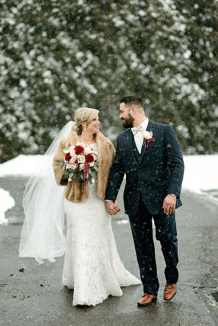Newlyweds walking together through falling snow