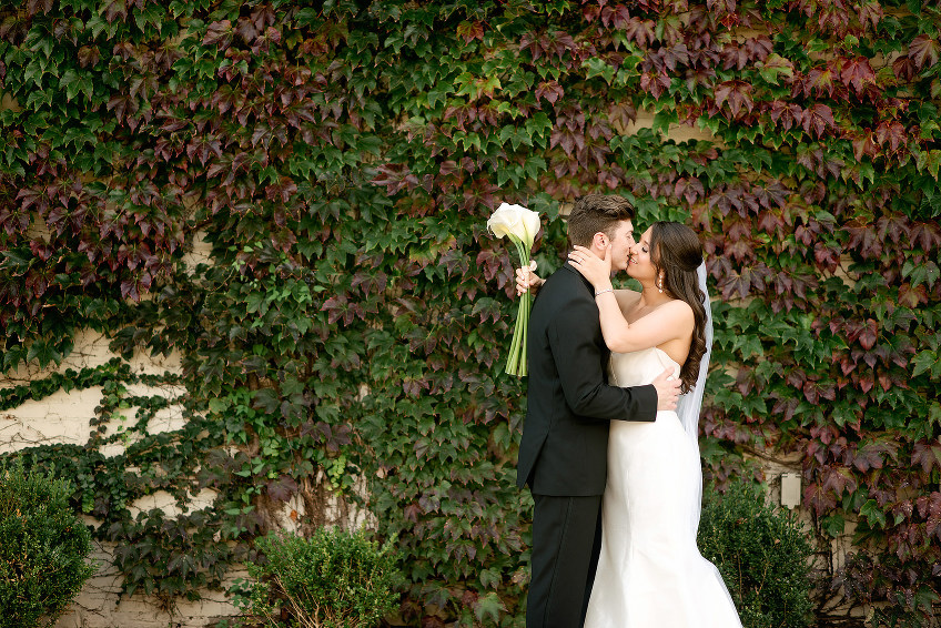 Bride and groom beside the ivy wall at J. Verno Studios